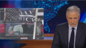Jon Stewart Mocks Media For Being Distraught Over Picture Of Biden Tied Up In The Again Of A Truck