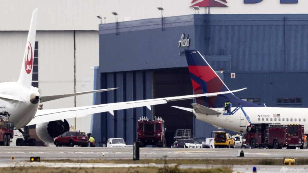 Japan Airways airplane wing clips parked Delta jet at Seattle airport